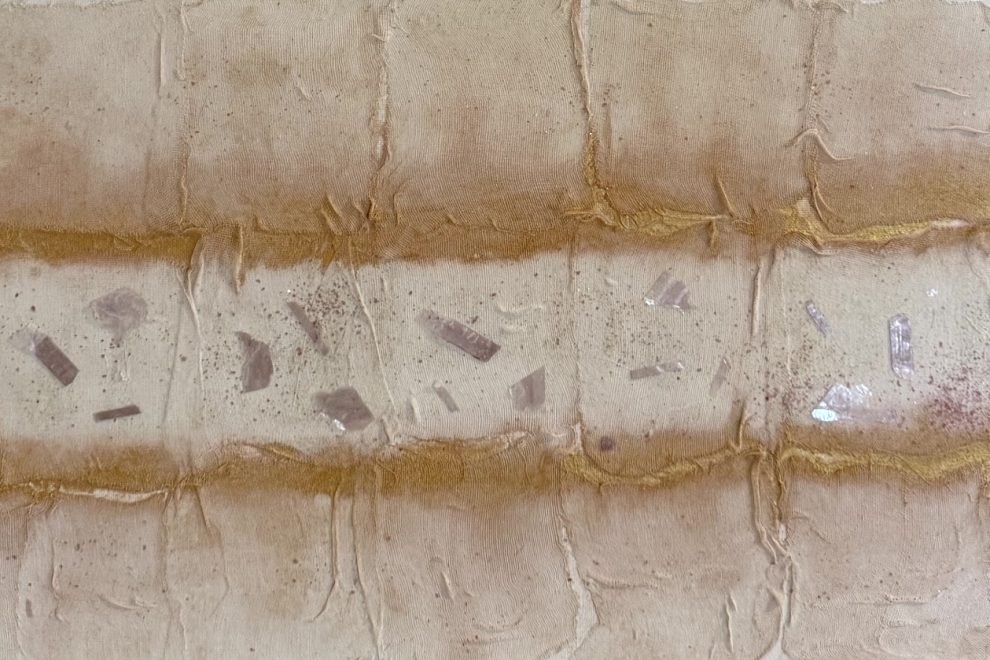 Kristallsplitter glitzern auf cremefarbigem Untergrund, am oberen und unteren Bildrand sind übermalte Gazebinden aufgeklebt.